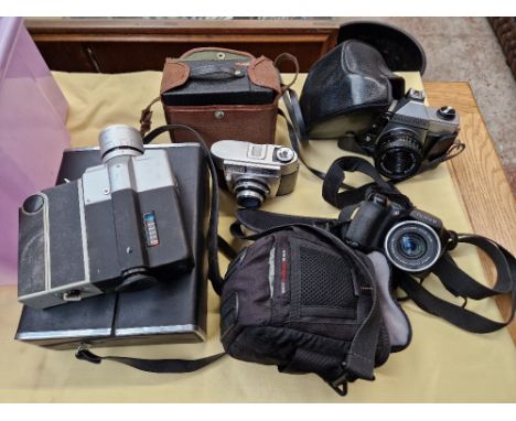 A box of cameras including Praktica MTL 50, Fujifilm Finepix S5700, 8mm cine camera, etc.