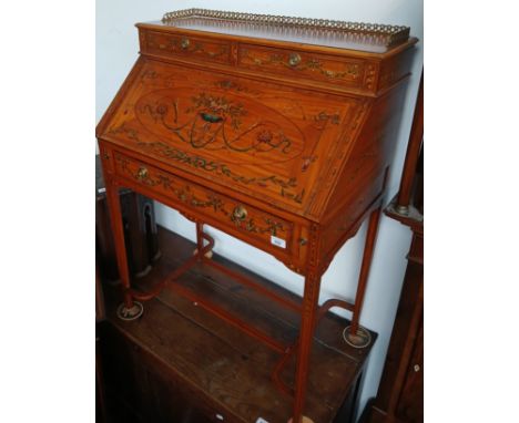 An Edwardian Sheraton Revival satin walnut ladies bureau, brass gallery rail, two drawers above drop down front revealing fit