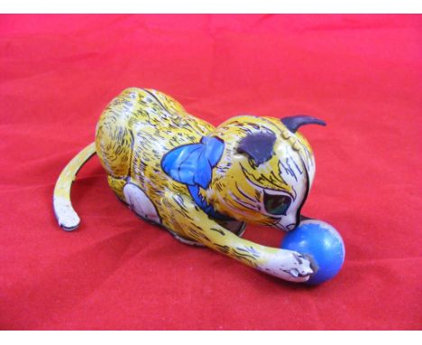 A tinplate clockwork figure of a Cat playing with a ball, with moving tail, approx length 14cm.