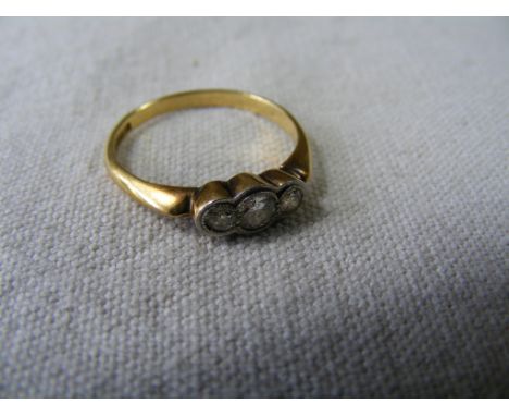 An 18ct Yellow Metal Ring, line-set with three small Diamonds in a carved White Metal setting, stamped ''18CT & PLAT''.