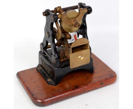 A skeleton type ticket punch made by EG Magrath, London, N1, raised on oak plinth, working order