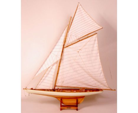 A static scale model of the 1899 racing yacht 'Columbia,' of wooden and brass construction, with white canvas sails, on displ