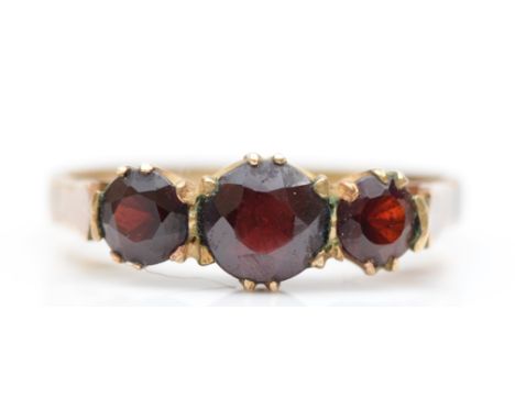 A 9ct gold three stone garnet dress ring, M-N, 2.1gm. 