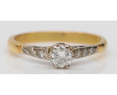 An 18ct gold brilliant cut diamond solitaire ring, with diamond set shoulders, central diamond estimated weight .20ct, K, 2.1