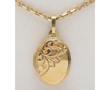 A 9ct gold oval locket with foliate scroll decoration, on 375 gold chain, 16 x 11mm, 5gm. 