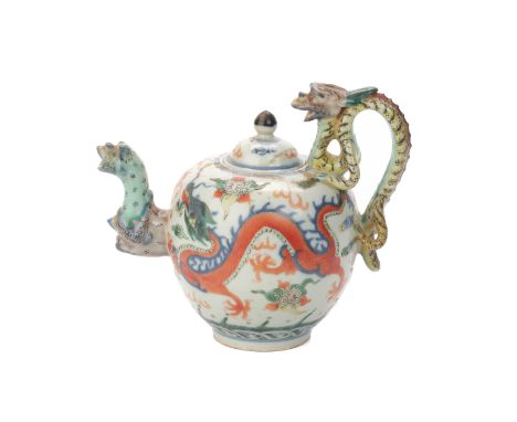 A WUCAI PORCELAIN DRAGON TEAPOT
The spherical body with two trailing dragons above crashing wavers, with dragon handle and be