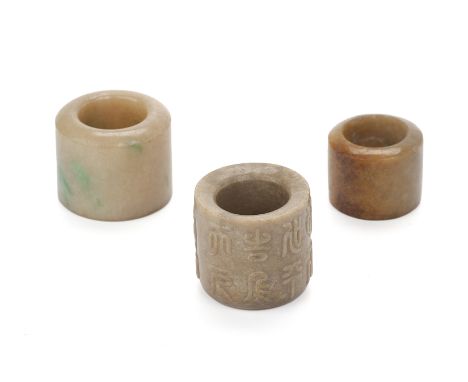 A GROUP OF THREE JADE ARCHERS RINGS
One of pale brown tone with vivd green inclusions; another smaller similar example with a