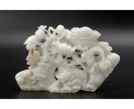 A WHITE JADE CARVING
Carved and pierced with a central dragon above crashing waves with a dragon fish, the reverse with a car