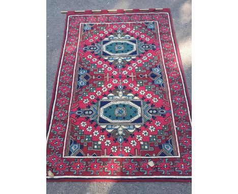 A Debenhams crewel work wall tapestry with tab heading depicting crosses amongst the border in reds, pinks, navy and green th