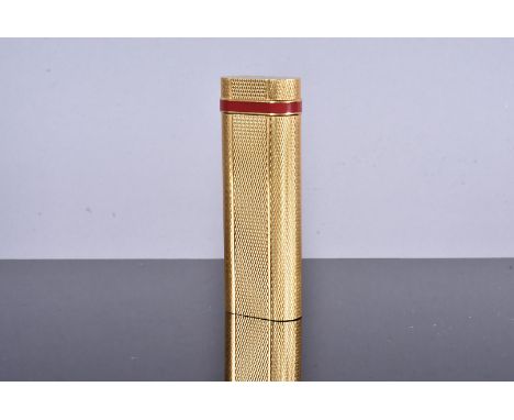 A Cartier gold plated pocket lighter, with engine turned design with red lacquer band to the top, serial 37209T, marked Carti