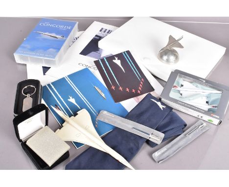 An assortment of Concorde related items, to include a jigsaw, VHS, Corgi model, paperweight, pens, brochures, in flight items