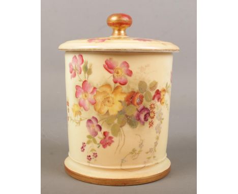 A Royal Worcester blush ivory lidded pot with hand painted floral decoration. Date mark for 1896. Height 14cm.  Crack to lid.