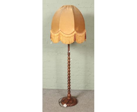 A barley twist standard lamp with fringed velvet shade.  