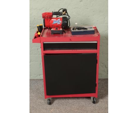 A red and black tool cabinet on casters with contents of assorted tools to include Clarke Wiz Air table top compressor, ballp