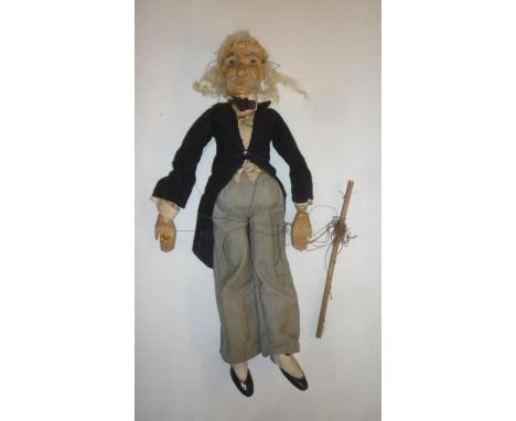 A late Victorian male puppet, carved painted wood head, inset glass eyes, grey wool hair and moustache, in black tail coat an
