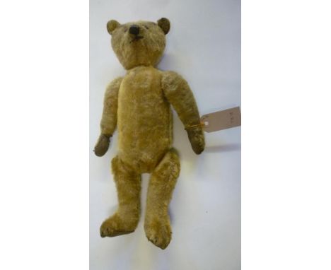 A teddy bear, pre-war, straw filled, covered in dark gold plush, swivel joints, black button eyes, cloth pads, 15 1/2" high