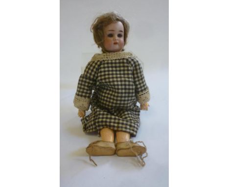 A Kammer & Reinhardt bisque head doll with blue glass sleeping eyes, open mouth and teeth, brown mohair wig, jointed composit