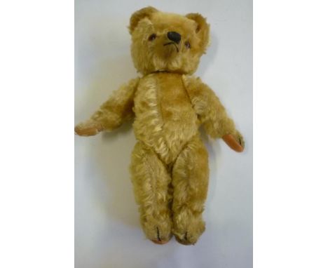 A Chad Valley teddy bear, covered in gold plush, swivel joints, amber/black eyes, orange felt pads, with button to right side