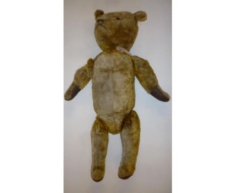 An English teddy bear, c.1935, with swivel joints, straw filled, black/amber glass eyes, later canvas pads, 23" high