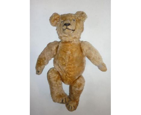 A German teddy bear, c.1940, gold plush straw filled, swivel joints, amber eyes, felt pads, 12" high