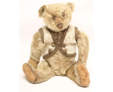 A Steiff teddy bear, c.1910, straw filled, covered in dark blonde plush, swivel joints, brown button eyes, cloth pads, 13 1/2