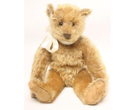 A Steiff teddy bear, c.1910, straw filled, covered in gold plush, swivel joints, black button eyes, felt pads, 12 1/2" high (