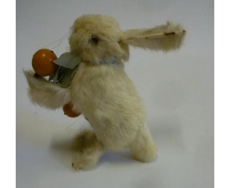 A French Descamps clockwork white rabbit, c.1910, with glass eyes, standing on his hind legs and balancing on his tail, playi