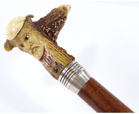 A walking stick with carved mask decorated horn handle 