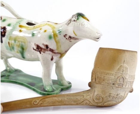 A Staffordshire Pottery cow creamer, and a Crystal Palace commemorative clay pipe, both A/F (2) 