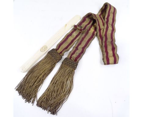 A Victorian ivory page-turner with relief carved crest, length 39cm, and a gold braid embroidered sash 