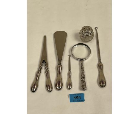 A silver hafted magnifying glass and a silver hafted glove stretcher, shoe horn and two button hooks with a small silver topp
