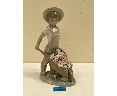 A Lladro figure, boy with a wheelbarrow of flowers. 9¼" high.