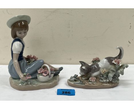 A Lladro figure of a seated girl with a basket of flowers, 6¼" high and a Lladro cat and frog group.