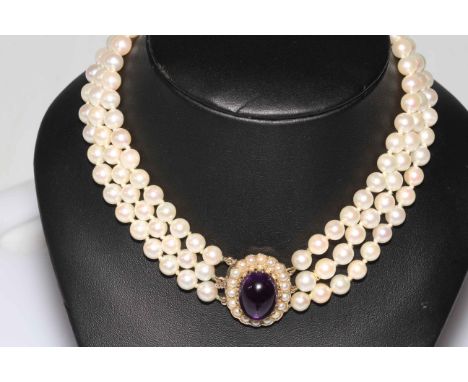 Pearl choker necklace having three strands of uniform pearls with large cabachon amethyst and seed pearl 9 carat gold clasp, 