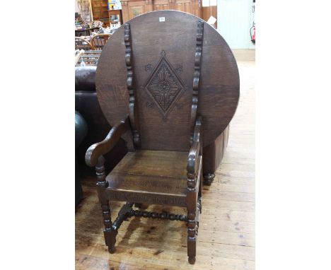 Carved oak monks seat on bobbin legs, 74cm by 90cm diameter.