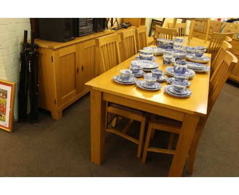Light oak eight piece dining suite comprising three door sideboard, rectangular dining table and six rail back dining chairs.