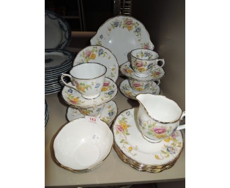 A collection of Royal Albert cups and saucers, sugar basin,jug and plates having hand tinted floral pattern.