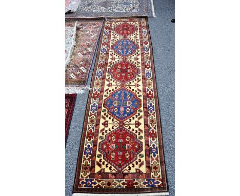 A fine Persian wool hand knotted pile rug runner, with a light central field and five medallions and multiple borders, 272cm 
