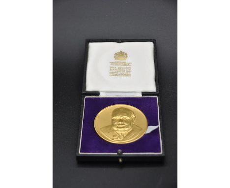 A cased Gilded Silver  Sir Winston Churchill commemorative medallion, John Pinches, obverse full face portrait, reverse coat 