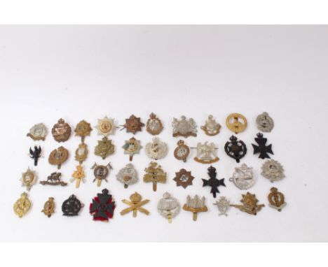 Group of forty British military cap badges to include Machine Gun Corps, Cheshire Regiment and Royal Army Medical Corps