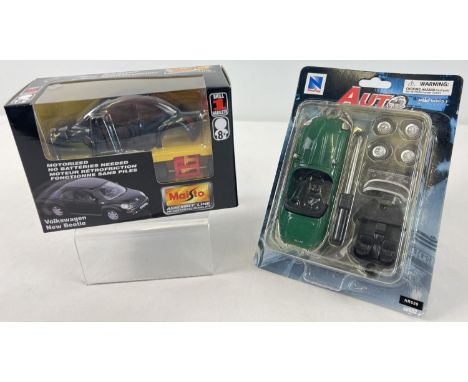 2 boxed 1/43 scale diecast vehicle kits. Maisto 2000 new Beetle in black kit #29410, together with New Ray Toys Jaguar in gre