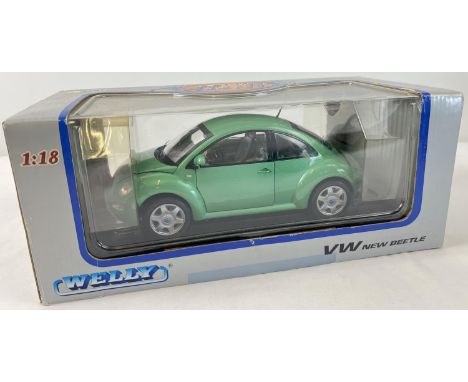 A boxed 1/18 scale Welly diecast model of a Volkswagen Beetle in metallic green. On black plastic plinth. No. TY2991. 