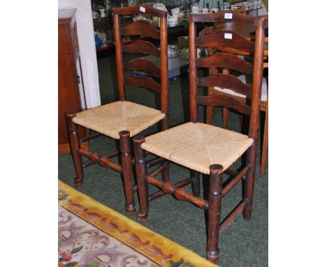 A pair of 19th Century country-oak ladder back dining chairs with rush seats