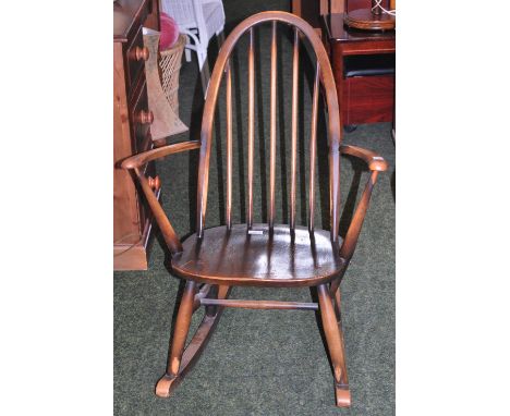 An Ercol elm rocking chair of small proportions.