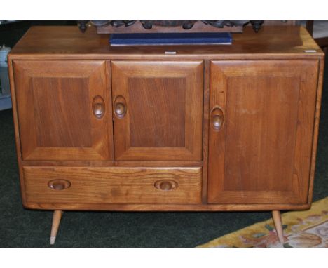 An Ercol sideboard in elm, comprising a single door cupboard and drawers. Height 82 cm 115 cm wide.