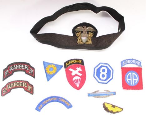 Collection of WWII era US military cloth and bullion patches and badges, including a US Navy Officers hat badge and band, 4th