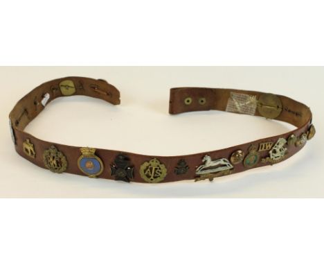 Leather army style belt mounted with various cap badges and military buttons, mostly British, including RAF, West Yorkshire, 