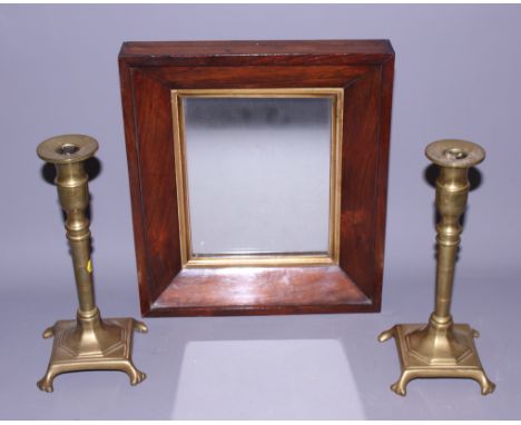A pair of 19th century cast brass candlesticks, on square bases, and a rosewood framed wall mirror