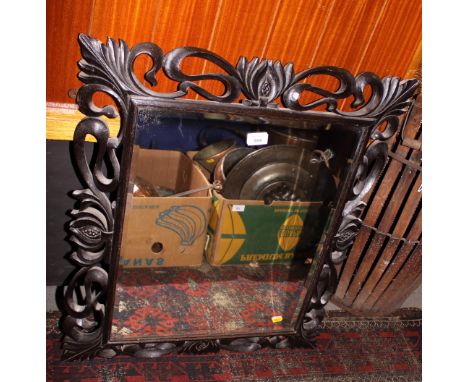 A carved and ebonised pierced frame wall mirror, plate 17 1/2" x 21"
