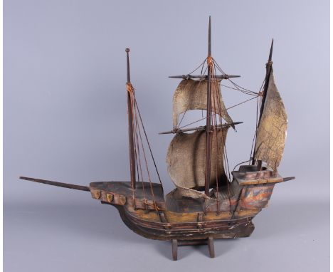 A wooden scale model of a single scull with oars, 39" long, and a model galleon, 24" long